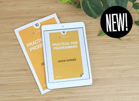 Practical Pair Programming on table in paperback and ebook format.