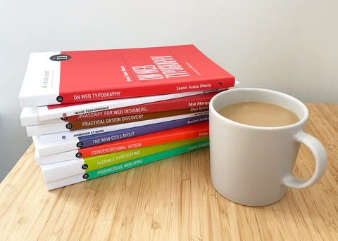 Stack of A Book Apart books next to a cup of coffee