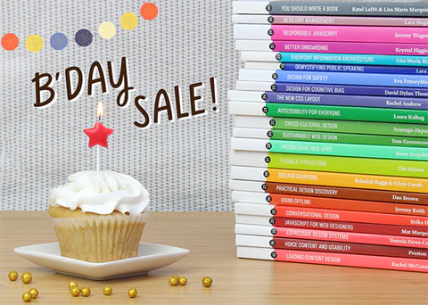 A vanilla cupcake with white frosting and a star-shaped red candle sits beside a stack of colorful paperback books. Text reads: B'Day Sale!