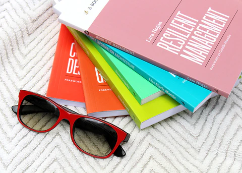 Stack of A Book Apart books and sunglasses on a beach towel